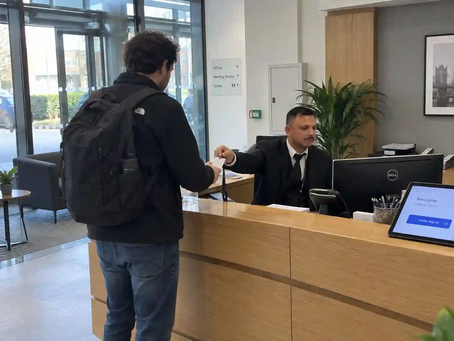 Corporate concierge security officer controlling access at a London office entrance