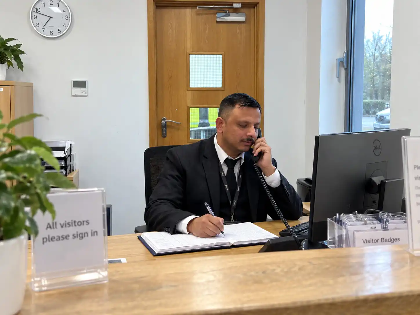 Corporate concierge security officer managing reception at a London office building